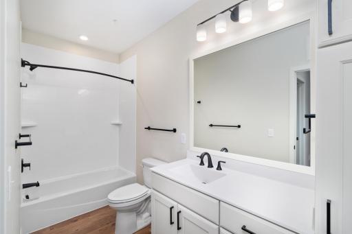 It boasts ample closet space and is conveniently located near the full bathroom, which features modern finishes