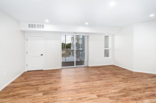 The large living room is bathed in natural light, offering flexible layout options and direct access to a screened-in maintenance-free deck, where you can relax and enjoy the outdoors in comfort year-round.