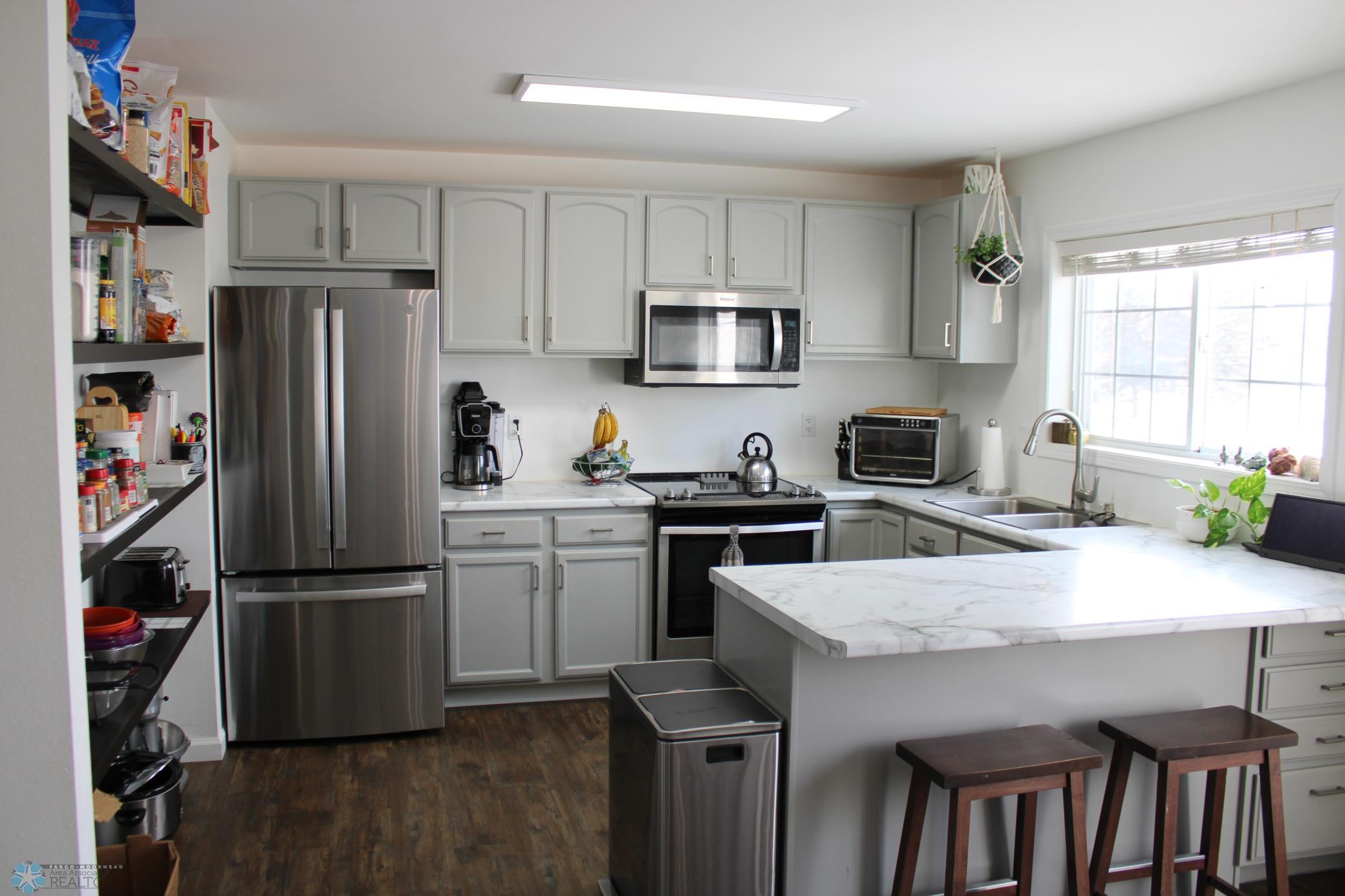 So many updates here, newer countertops, appliances, open pantry, painted cabinets and lighting!