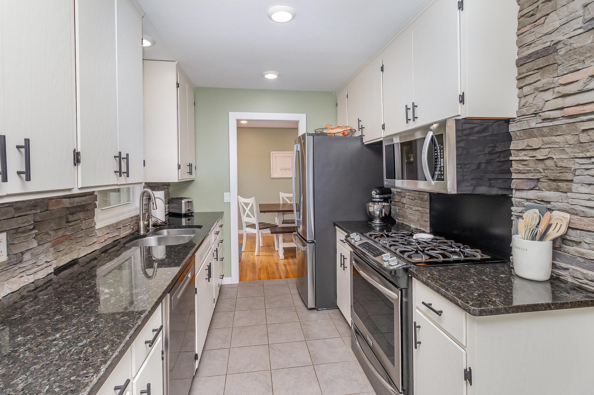 Look at the fresh look of this kitchen with its stainless steel appliances and white cabinetry.