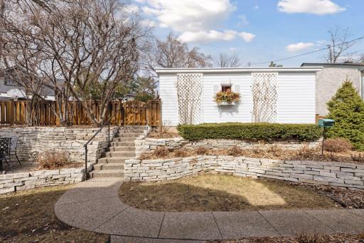 The back yard is private and inviting with terraced gardens, professional landscaping, and a patio for outdoor dining.