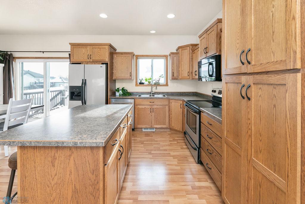 Kitchen w/ recessed lighting + stainless steel appliances