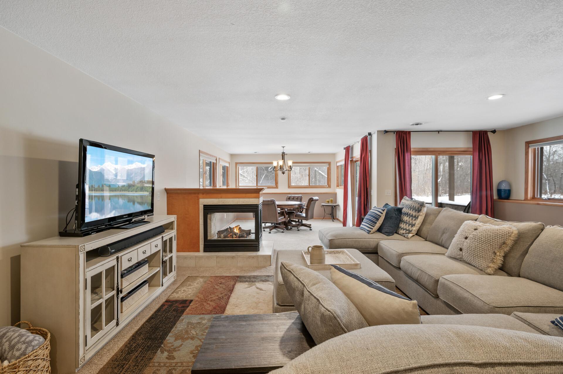 Gorgeous lower level family room w/3 sided gas fireplace and so much natural light!