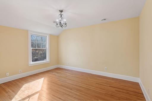 Generous bedroom with quaint chandelier & refinished hardwood floor. Plus, built-in desk and organized closet.
