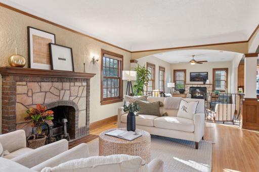 The Living room with wood burning stone fireplace, cove ceilings with picture molding and custom columns.