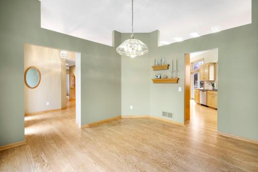 Dining room with hardwood floor, oak floating shelves, access to and from the kitchen and foyer.