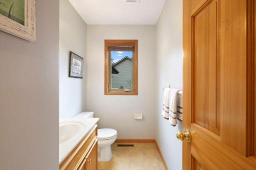 Main floor half bath with oak vanity cabinet and natural light