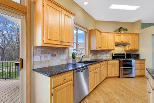 Quartz countertops, natural stone tile backsplash and composite quartz sink