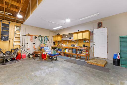 Oversized 3 Car garage features additional area for a workbench and storage, entry door with backyard access