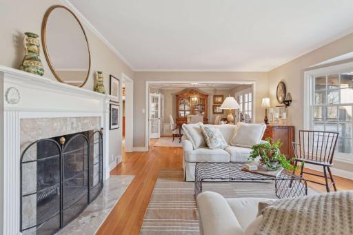 Formal living room with wood burning fireplace and large bay window overlooking the woods.