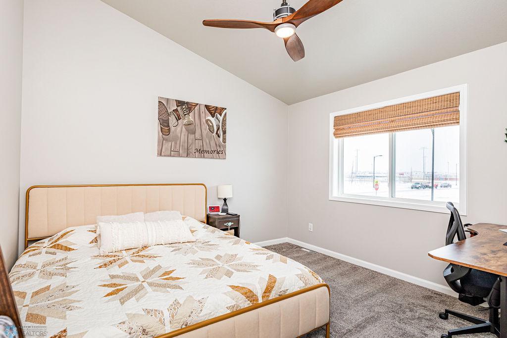 Spacious Primary Bedroom with vaulted ceilings, cozy carpet, ceiling fan.
