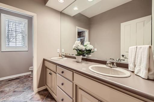 This bathroom with double sinks is shared by 2 bedrooms