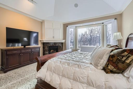 Spacious Primary bedroom with gas fireplace and high coved ceilings