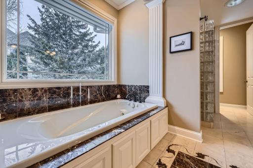 Primary jetted tub and walk-in shower with rain and wall shower