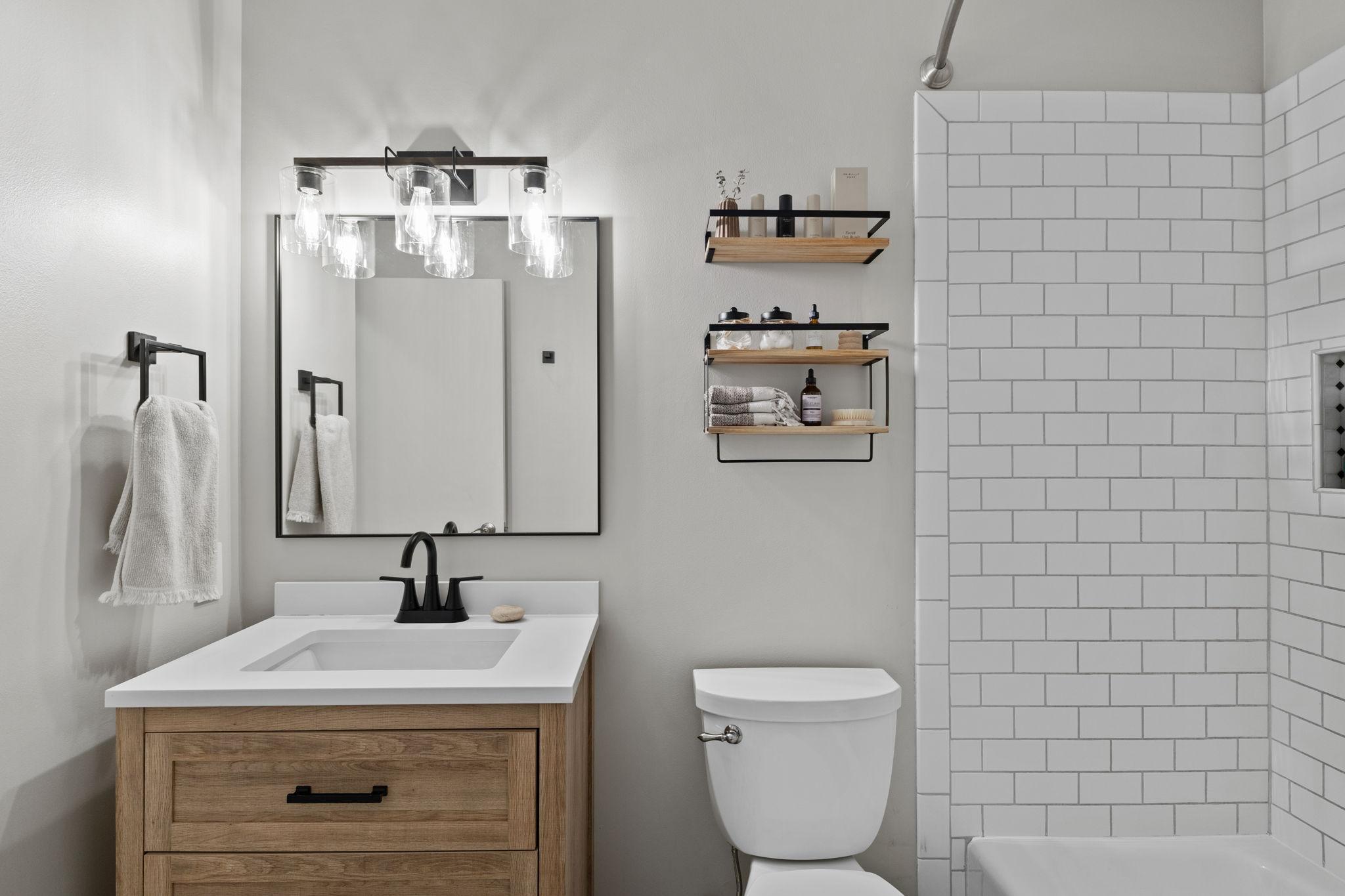 Upper level full bathroom. It is a beautifully updated bathroom with a modern, minimalist design. Access is from the main hallway AND the master bedroom.