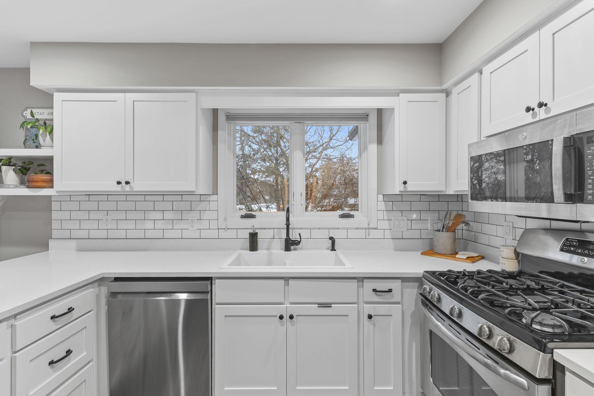 A bright and stylish kitchen with a modern farmhouse aesthetic. The white quartz countertops provide ample workspace, making this kitchen both functional and inviting. The window faces the front yard.