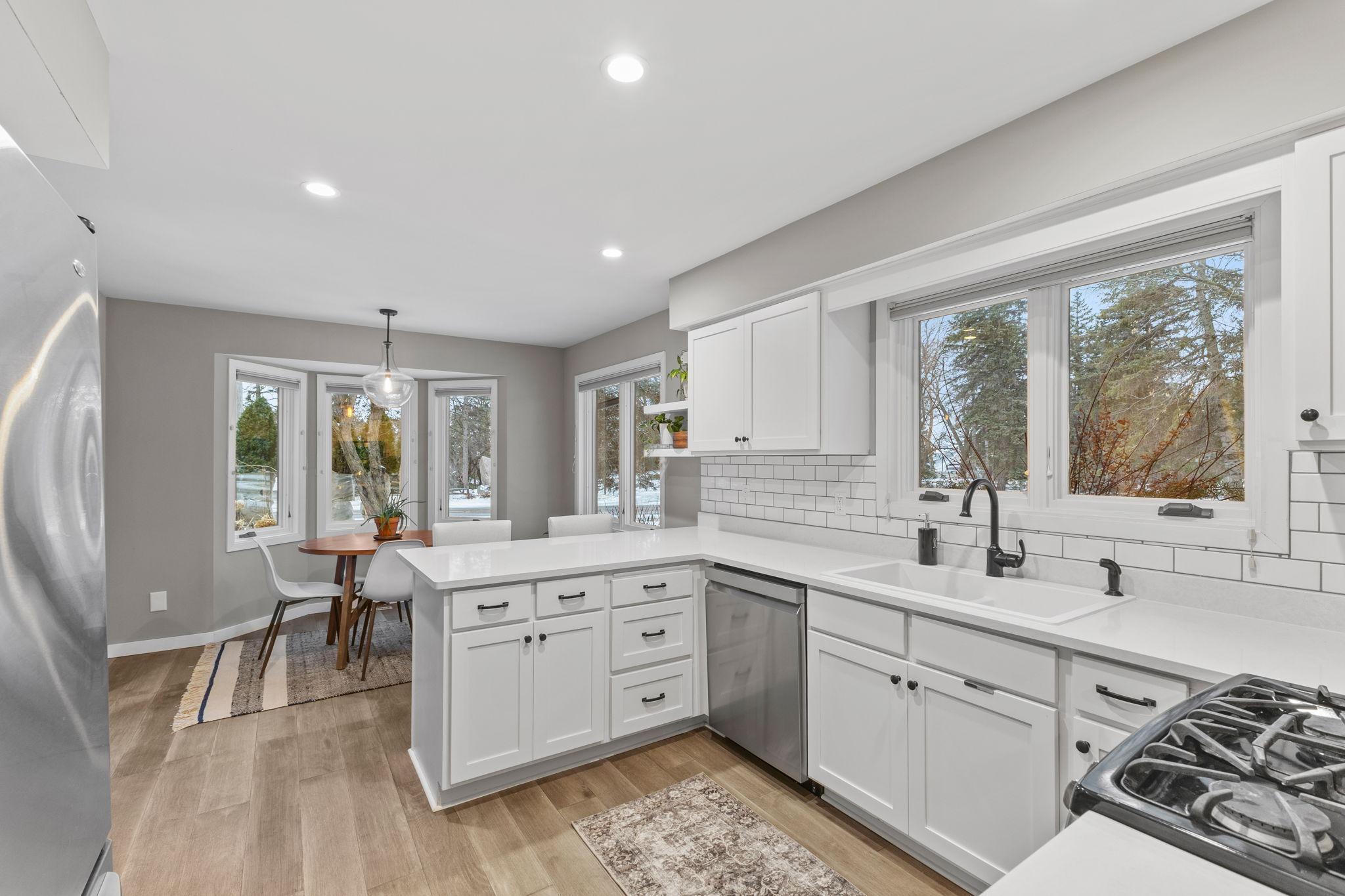 The kitchen sits off the front foyer. Updated appliances, countertops, floors, paint, tile, and fixtures. Custom blinds throughout! To the left of the eat in breakfast area is a side door to the maintenance-free deck.