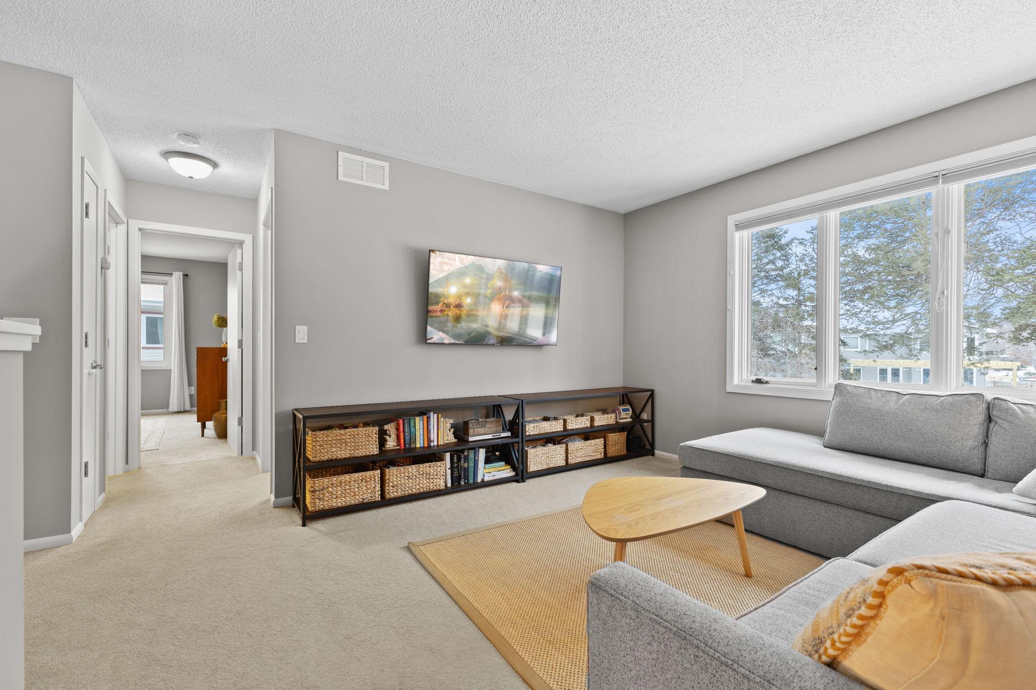 This is another view of the upper level living room. The main bedroom is the open door and the second upper level bedroom is to the right of that . The upper level full bath is to the left of the open doorway.