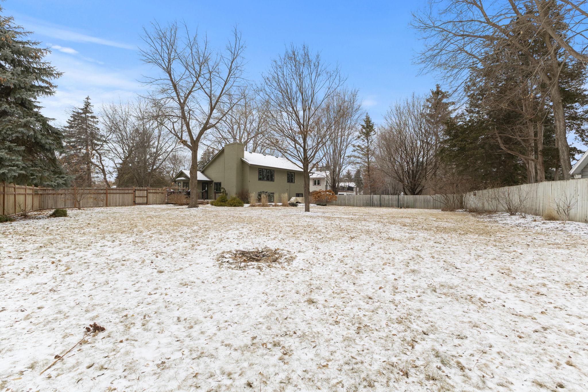 A winter view from the south side of the lot, with the firepit subtly nestled within the landscape.