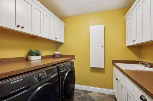 Upper level laundry with cabinets and sink
