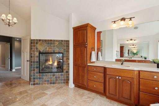 Double sided fireplace to set the mood of relaxation in primary bath