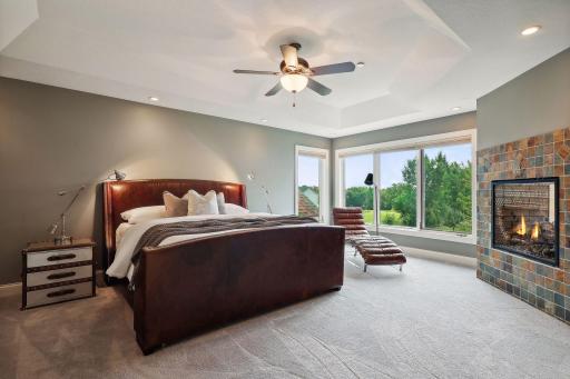 Oversized primary bedroom with serene views of trees and horse pastures