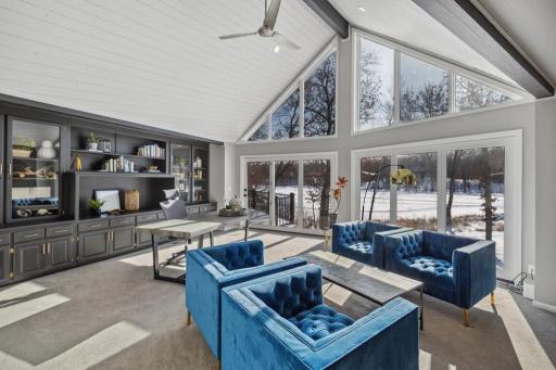 With vaulted ceilings, natural wood beams and a wall of floor-to-ceiling windows framing panoramic lake views, this home office provides a stunning backdrop to your workday.