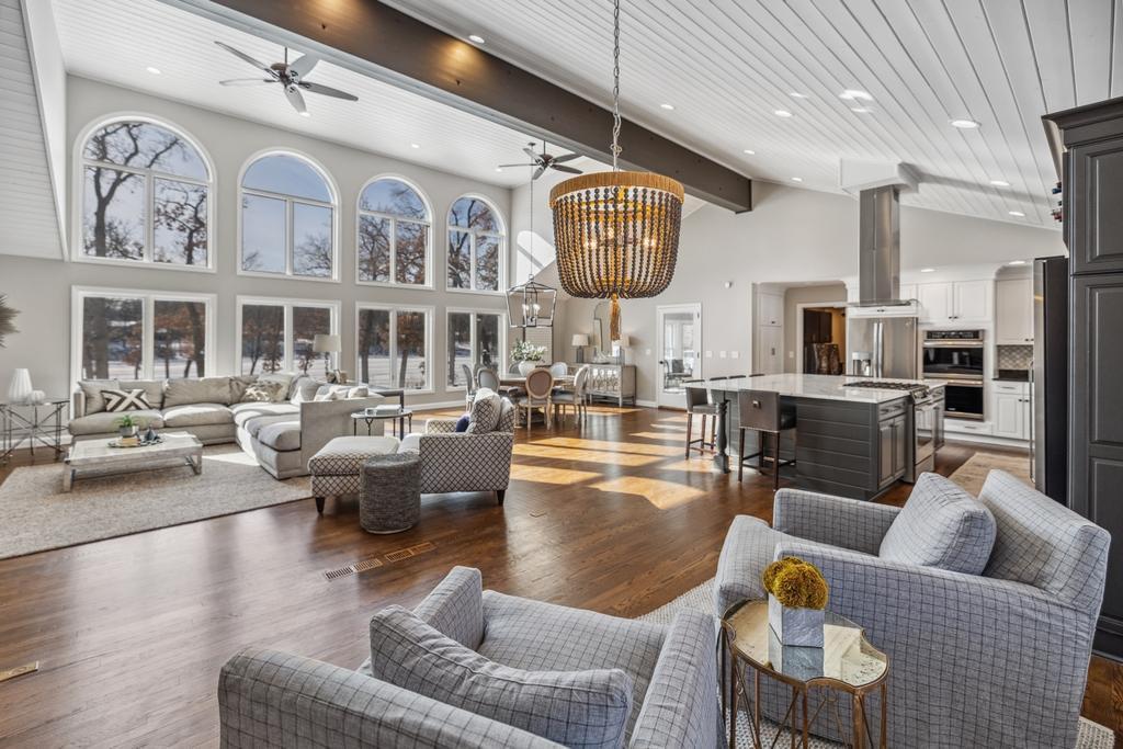 The rich hardwood floors enhance the inviting ambiance, seamlessly connecting this open-concept space to the kitchen and dining area.