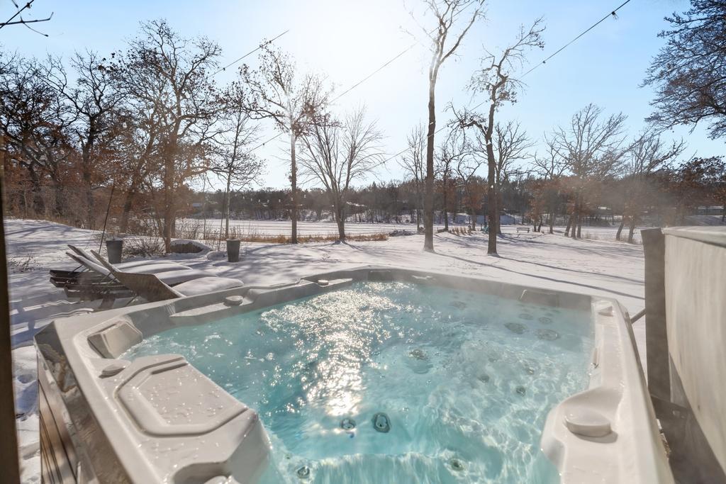 Just outside, a spacious patio features a private hot tub, perfectly positioned to take in the beauty of the water.