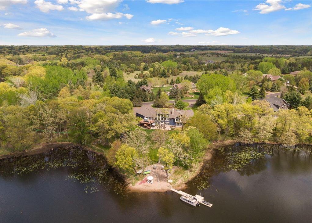 Tucked away in a private corner of Mahtomedi on nearly 4 acres, this exceptional home boasts 400 feet of lakeshore on Long Lake — perfect for days spent boating, swimming, and fishing.