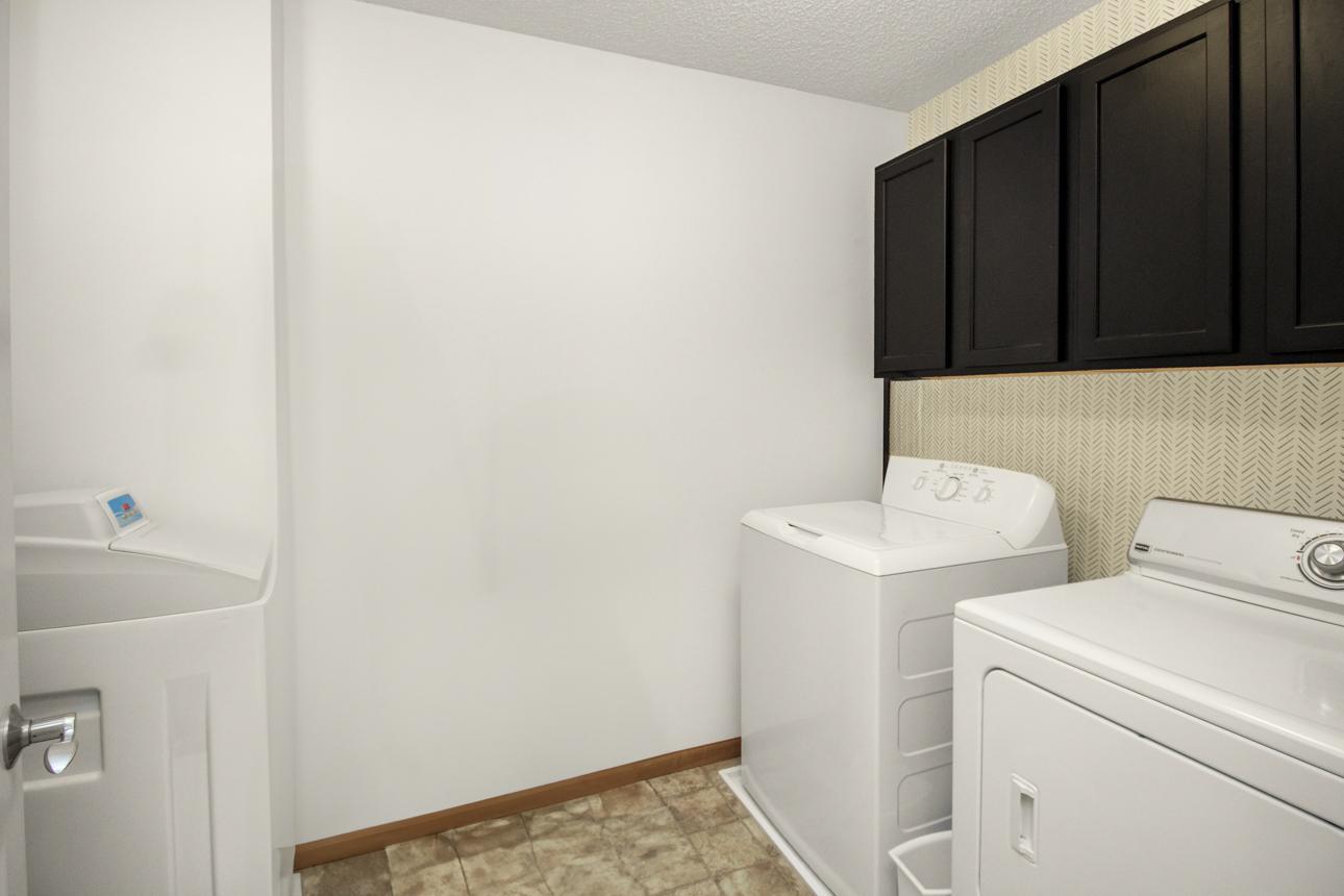 Upstairs laundry with storage cabinets.