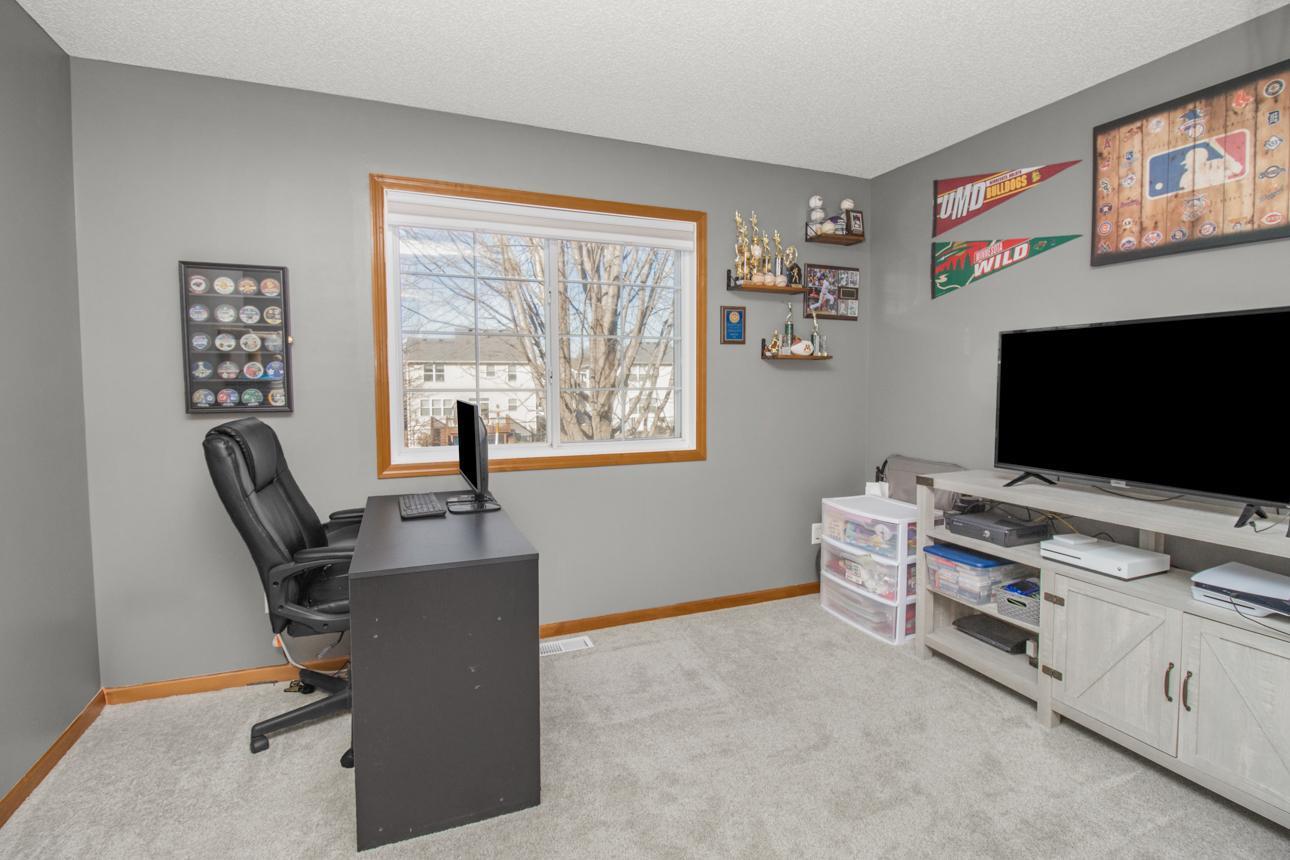 Bedroom two of three on the upper level. Currently serves as an office. Spacious, well lit and double door closet offers storage.