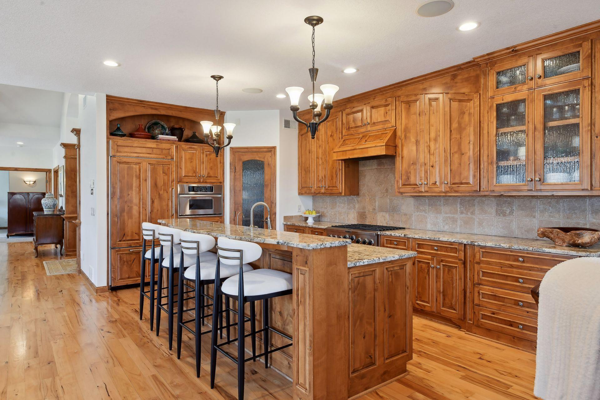 The gourmet kitchen is a sight to behold - gorgeous Alder wood cabinetry, granite countertops, tile backsplash, a 6-burner gas range, and a spacious pantry.
