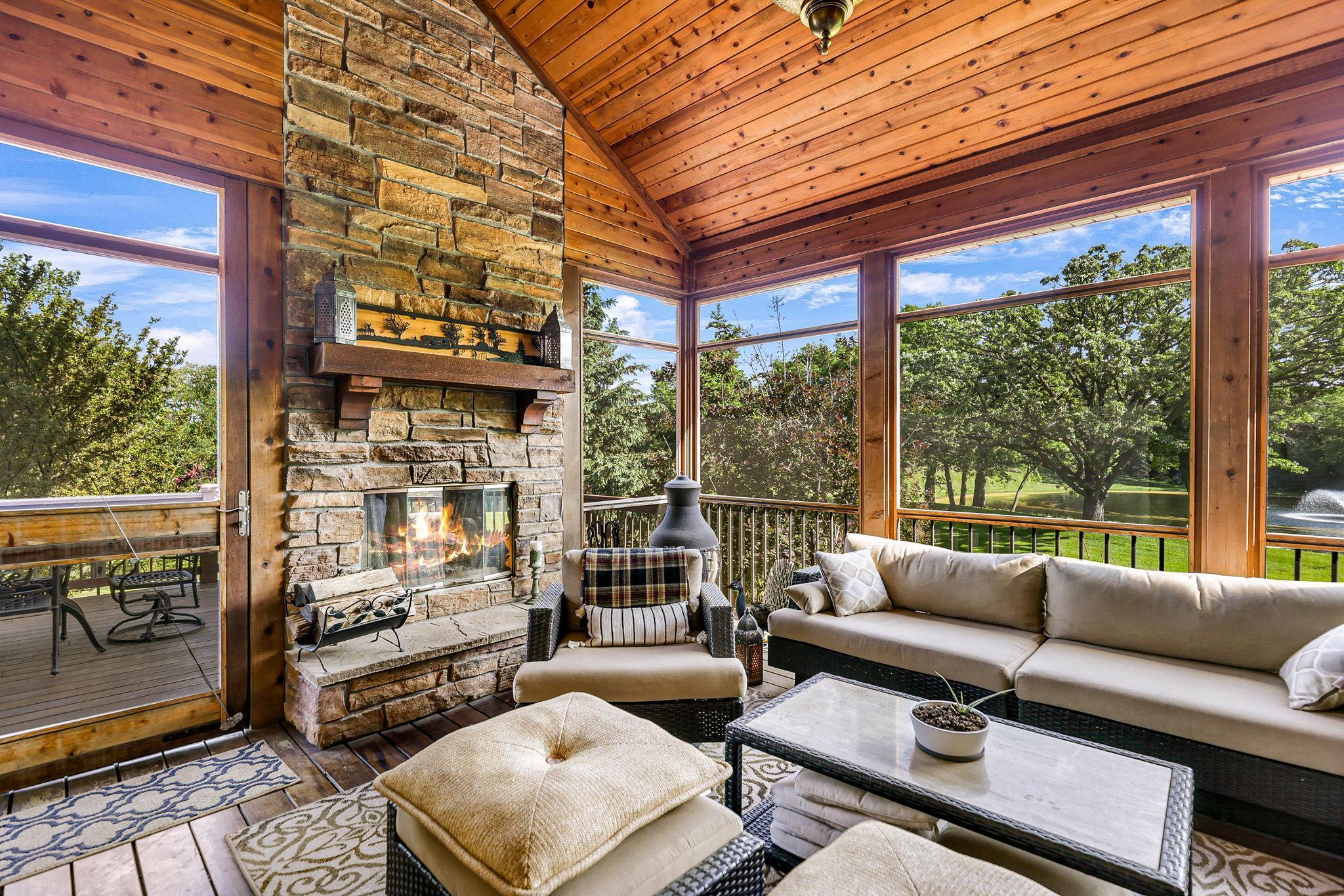 The inviting screened hearth room has a gorgeous wood-burning fireplace and is perfectly situated through the kitchen offering a wonderful retreat throughout the day and night!.
