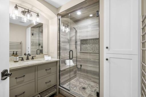 Luxury 3/4 ensuite bathroom with gorgeous tiled shower with bench, in-floor heating, and plenty of cabinet space.