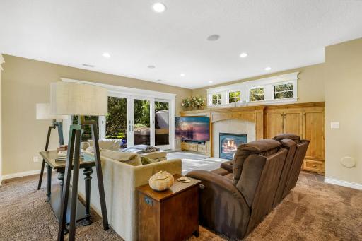 Lower level family room with gas fireplace, built ins, tons of natural light and easy access to the backyard Jacuzzi hot tub and pool area.