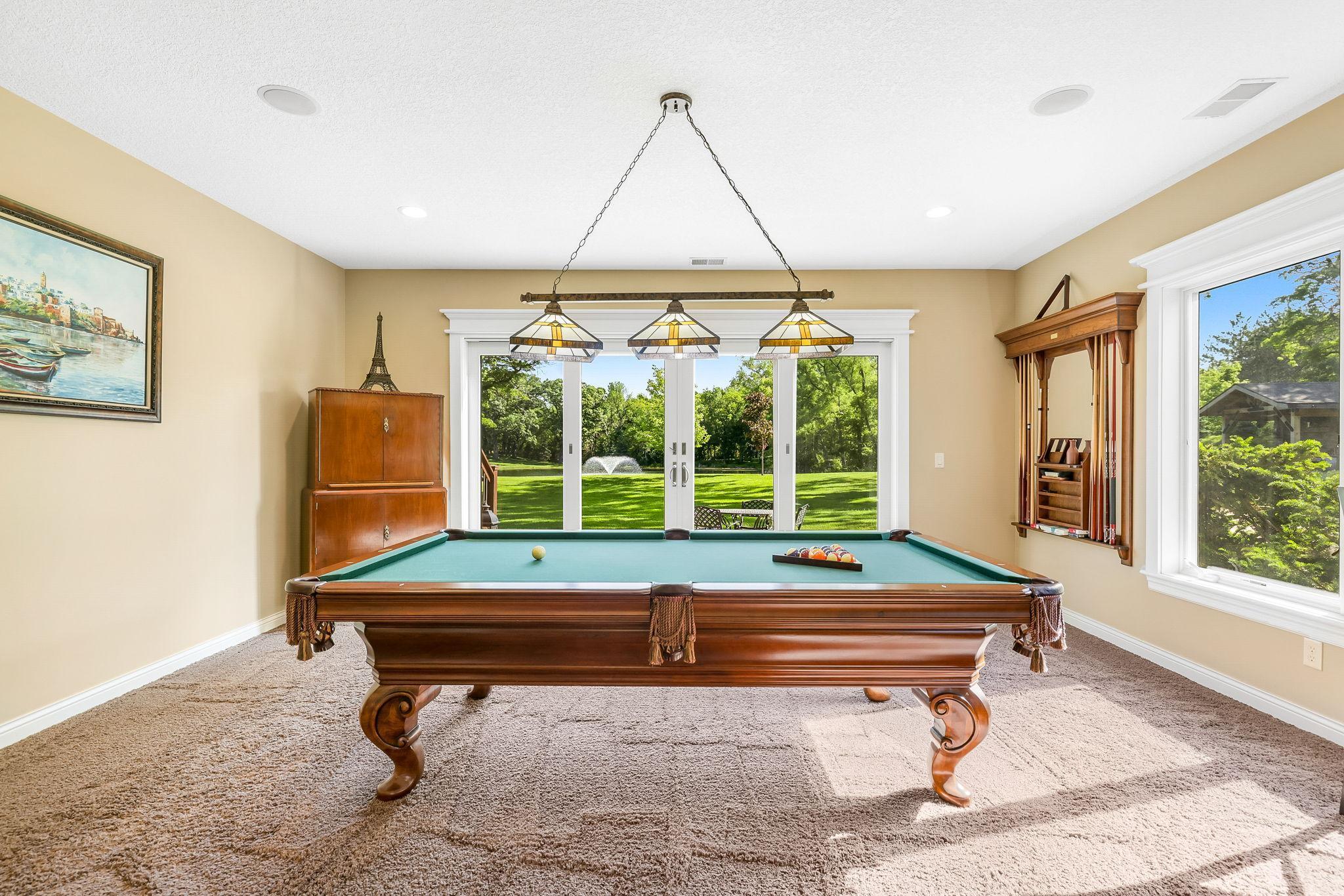 Billard room in the walkout lower level overlooking backyard paradise.