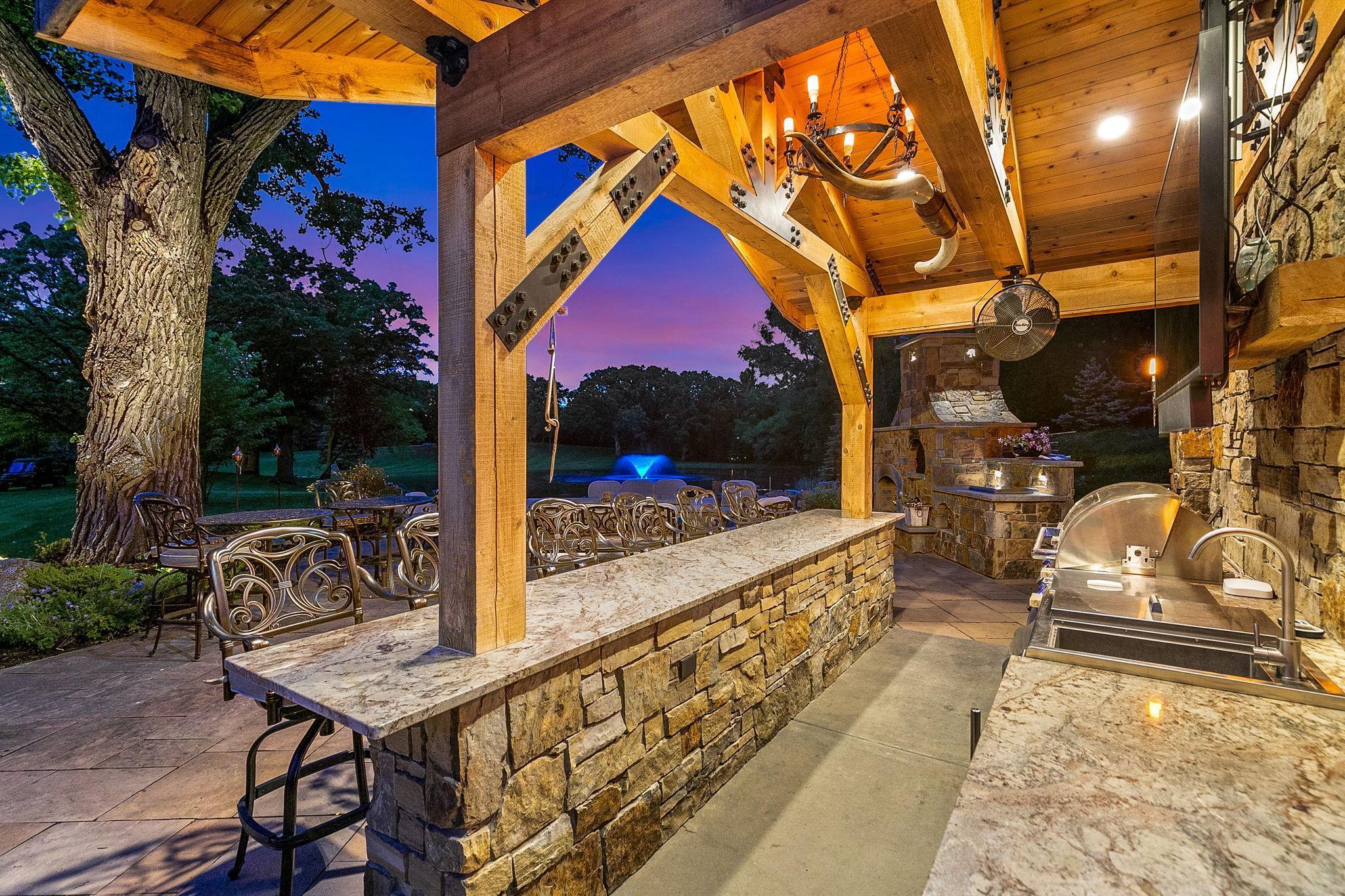 An evening view from the incredible outdoor kitchen - with the gorgeous lighting on the pond fountain and tree.