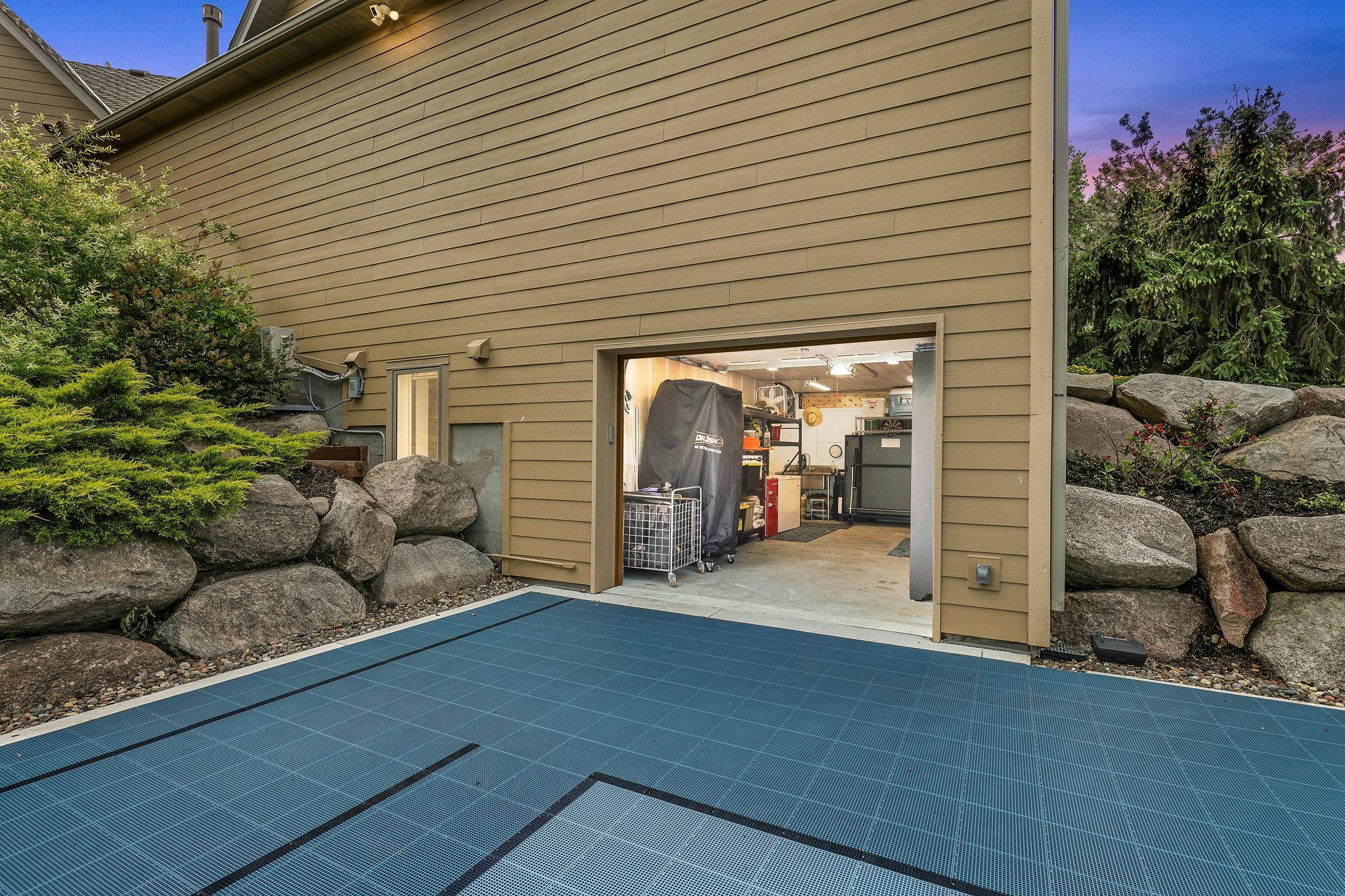 Lower level tuck-under garage/work shop area opens to backyard/sports court area.