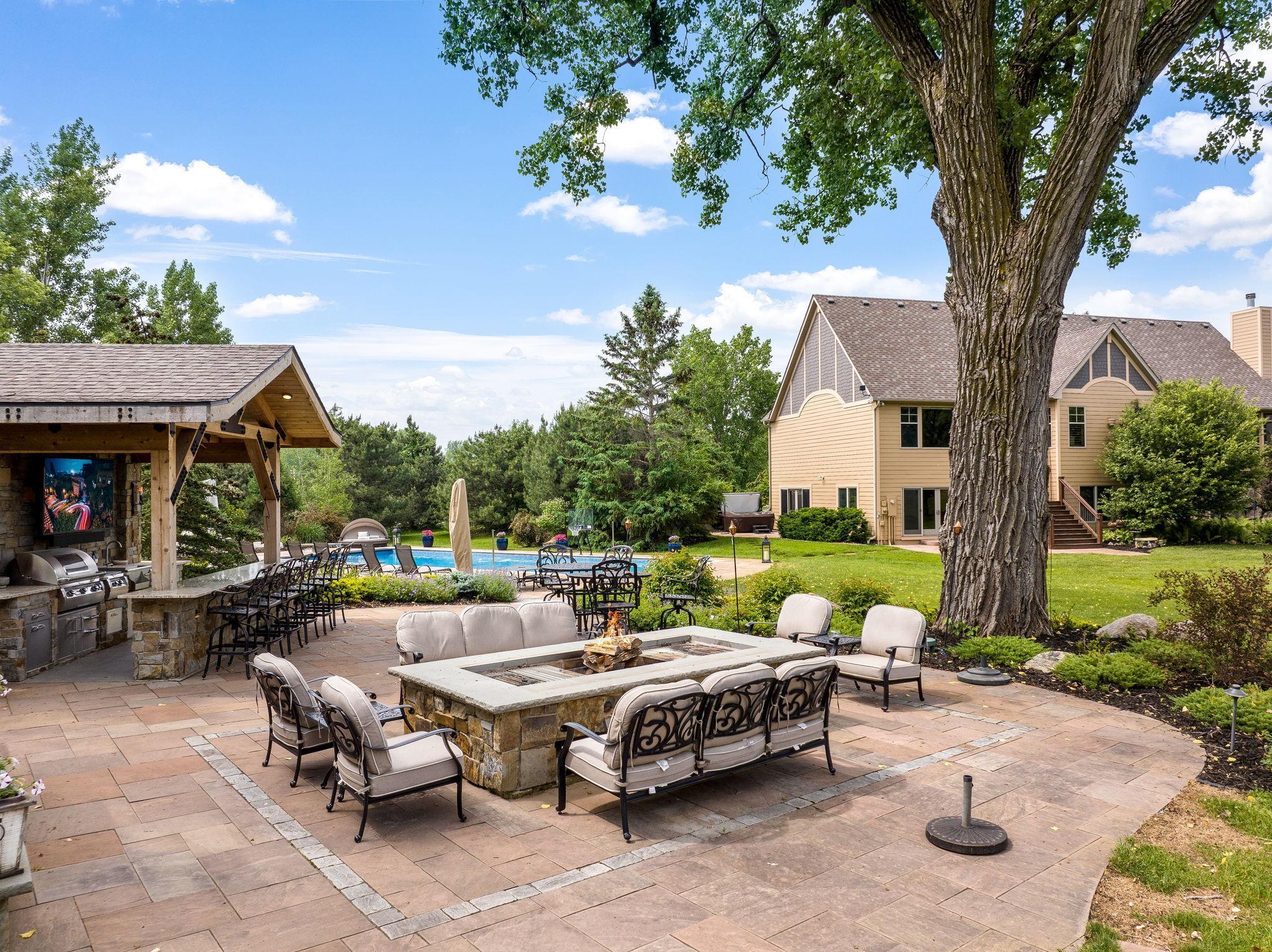 The outdoor kitchen and pizza oven were built behind the majestic tree to keep the natural flow of the property and to make it part of the amazing scene esthetically for beauty and functionally for shade around the stone fire and cooking table.