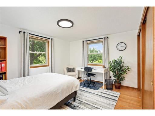 Bedroom four on the upper level also has windows for natural light. There is natural wood flooring throughout the upper level.