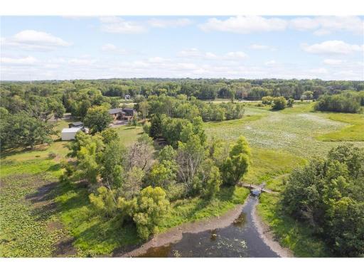This shows the bridge that leads from the main area of the property to a serene space surrounded by ponds with a trail running through it