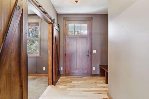 Step into a welcoming foyer featuring rich hardwood floors and a built-in bench with hooks and cubbies, perfect for keeping essentials organized.