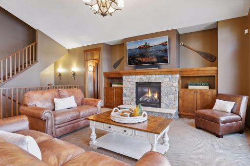 The fireplace is flanked by custom built-in shelves and cupboards. This is a space where thoughtful design meets the tranquility of nature.