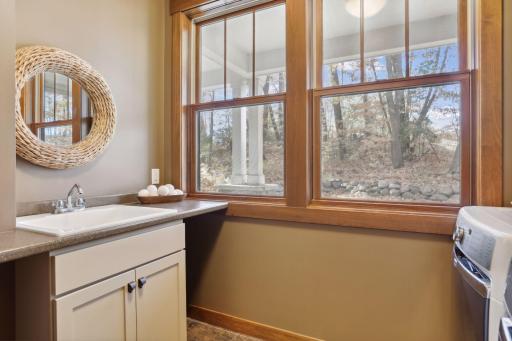 The main floor laundry room is both practical and spacious with ample cupboard space for storage and a handy laundry sink.