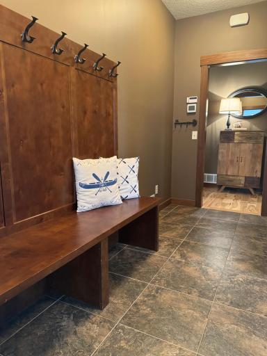 The mudroom features a spacious coat closet, a built-in bench for sitting as you take off shoes, and hooks and cubbies for storing coats, bags, and outdoor gear.