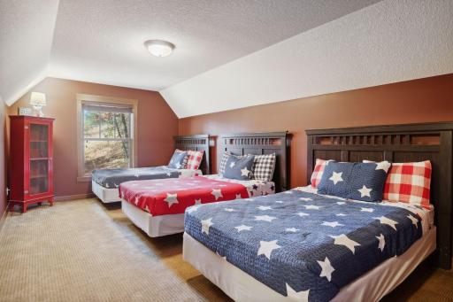 The upper level is a charming guest sleeping quarters. Perfectly designed as a cozy bunk room, it is ideal for accommodating friends and family, offering cozy sleeping arrangements for everyone.