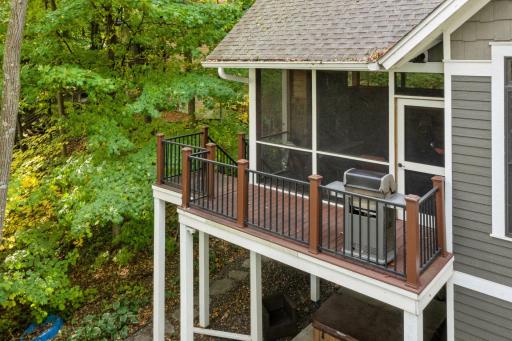 From the screen porch, step out onto the maintenance-free deck, which leads to the grilling area.