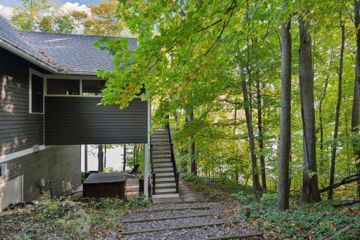 From here, stairs take you down to the patio, hot tub, firepit, and lake-side deck, making outdoor living easy and accessible.