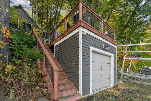 The lower level of the boathouse offers practical storage for watercraft and gear, while the deck above provides the perfect vantage point to take in the surrounding lakeside landscape.